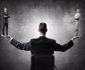 Businessman sitting in chair and holding in palms man and woman