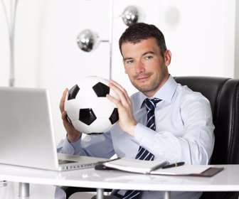 young businessman in office with computer and ball