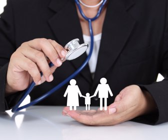 Businessman holding stethoscope with paper family