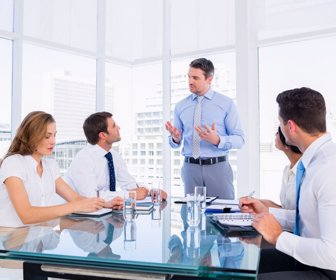 Smartly dressed young executives sitting around conference table in office