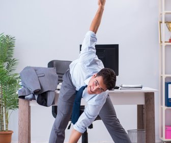 Businessman doing sports in office during break