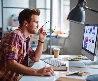 Man as a designer sitting at his table and working on computer