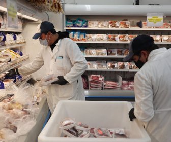 Los trabajadores reabastecieron estantes en el departamento de carne en el Supermercado Presidente en Miami el lunes